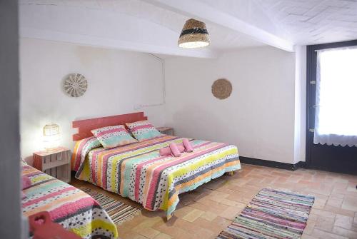 a bedroom with two beds and a table and a window at Casa del silencio Can Baldoyra in Espinavesa