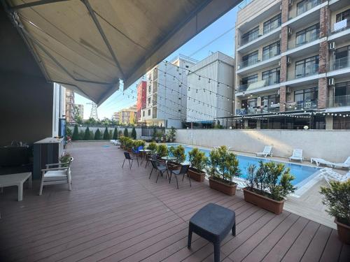 an outdoor deck with chairs and a swimming pool at Family Inn in Gonio
