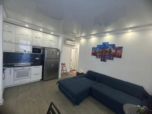 a living room with a blue couch in a kitchen at Family Inn in Gonio