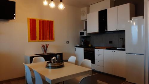a kitchen with white cabinets and a table with chairs at Peter Pan in Castellino Tanaro
