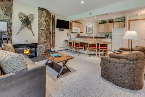 a living room with a fireplace and a kitchen at Laurelwood Condominiums 406 in Snowmass Village