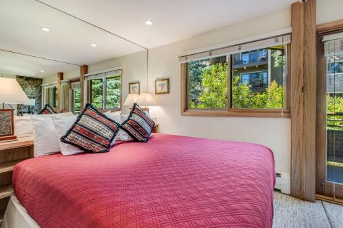 a bedroom with a large bed and two windows at Laurelwood Condominiums 406 in Snowmass Village