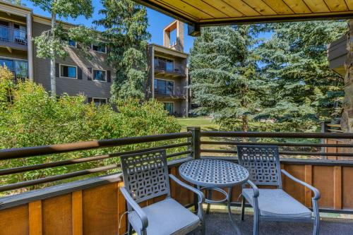 two chairs and a table on a balcony with a building at Laurelwood Condominiums 406 in Snowmass Village