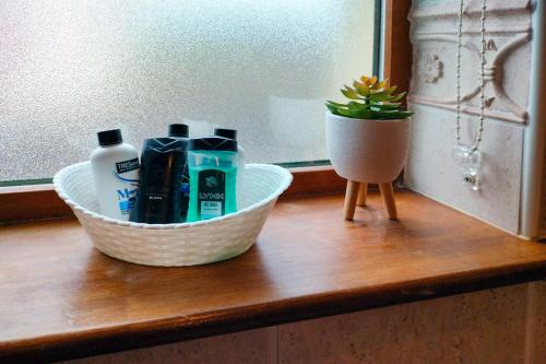 a basket with toiletries and a plant on a wooden counter at Tour House, A Country Escape set in Natures Beauty in Youghal
