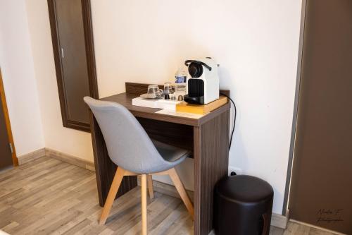 a desk with a chair and a coffee maker on it at Hotel de la Cathedrale in Beauvais