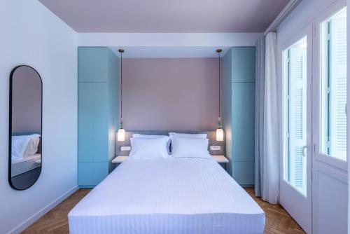 a bedroom with a large bed with blue walls and a mirror at Casa Navarino by Immobilis in Nafplio