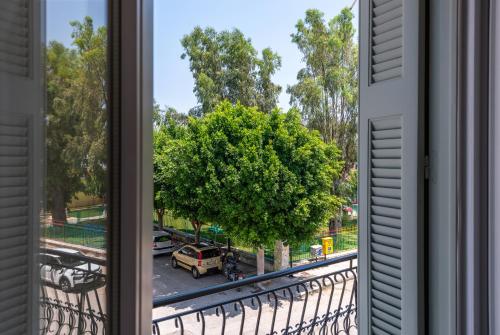 a window with a view of a street and a tree at Casa Navarino by Immobilis in Nafplio