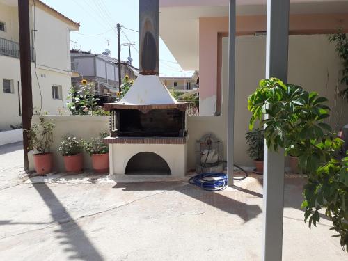 an outdoor pizza oven in a courtyard with plants at Vivari's Family House in Nafplio