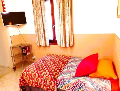 a bedroom with a bed with a colorful comforter and a window at Cozy!! Verona in Verona