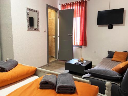 a room with two beds and a flat screen tv at Soba za goste Kraljica 4 in Kupres