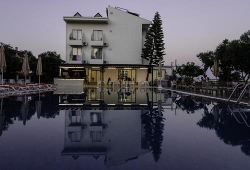 a building with a reflection in a pool of water at Side Sunset Hotel in Side
