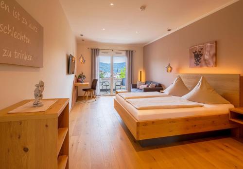 a bedroom with a bed and a living room at Main-Vinotel Weingut Helmstetter in Buergstadt
