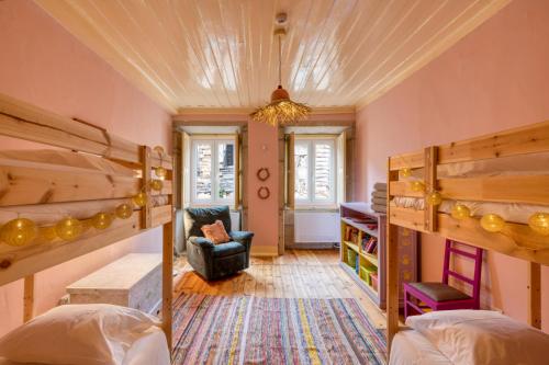 a bedroom with two bunk beds and a chair at Casa Trebaruna - refúgio numa aldeia do interior in Proença-a-Velha