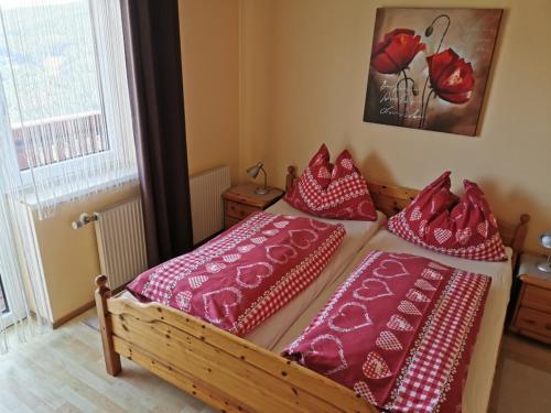 a bedroom with two beds with red and white pillows at Alpengasthof Fernblick in Mönichkirchen