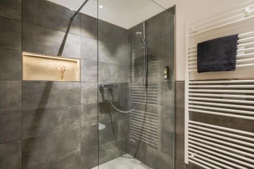 um chuveiro com uma porta de vidro na casa de banho em Main-Vinotel Weingut Helmstetter em Buergstadt
