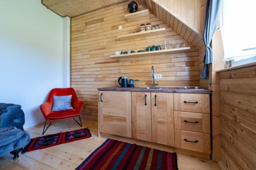 bagno con lavandino e sedia rossa di Apartments CENTER OF THE WORLD a Žabljak