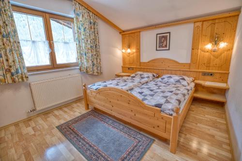 ein Schlafzimmer mit einem Holzbett in einem Zimmer in der Unterkunft Appartments Geisler in Achenkirch