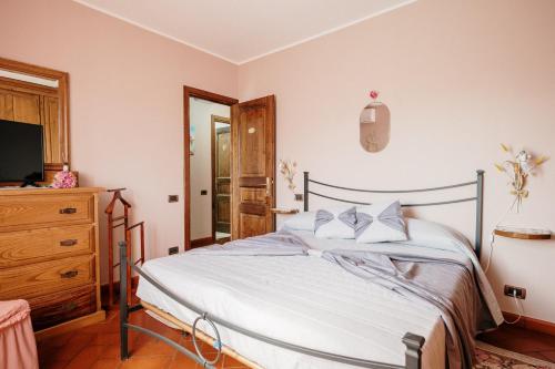 a bedroom with a bed and a dresser and a television at Lago del Turano - Guest House il Nido dell'Aquila in Ascrea