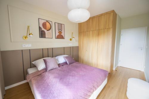 1 dormitorio con 1 cama con manta morada en Apartament Zoja II, en Elbląg