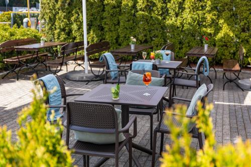 a group of tables and chairs in a patio at Hotel Bażantowo Sport in Katowice
