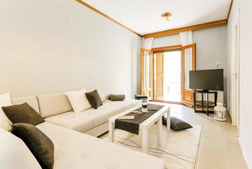 a living room with a white couch and a tv at 95sqm 7min Center 2bedroom Gas heating Marble Wc 2 SmartTv in Thessaloniki