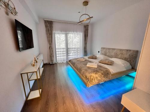 una camera da letto con un letto con una luce blu sul pavimento di Agi’s Apartment Predeal a Predeal