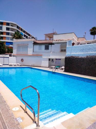 a large blue swimming pool in front of a building at Nice Apartment in Las Americas/Costa Adeje 1 in Playa de las Americas