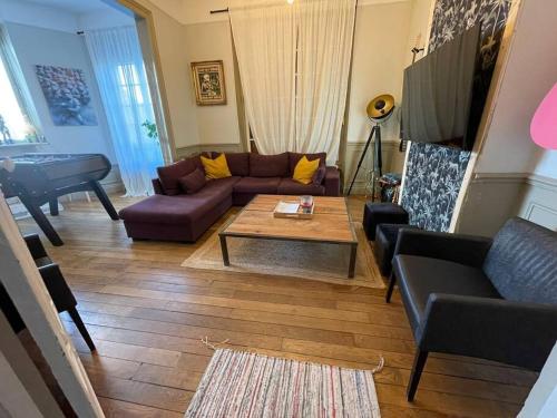 - un salon avec un canapé, une table et un piano dans l'établissement Gite d'exception 13 couchages avec jacuzzi et sauna, à Châlons-en-Champagne