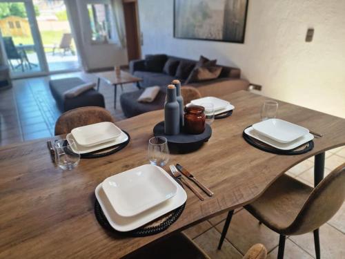 una mesa de madera con platos y servilletas encima en Stilvolle EG-Wohnung, en Jüchen