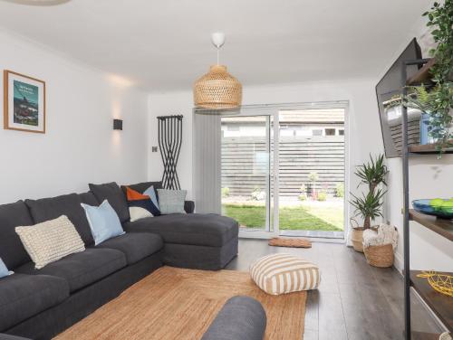 a living room with a gray couch and a window at Dolwyn in Menai Bridge