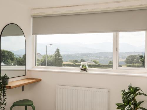 a window with a white blind in a living room at Dolwyn in Menai Bridge