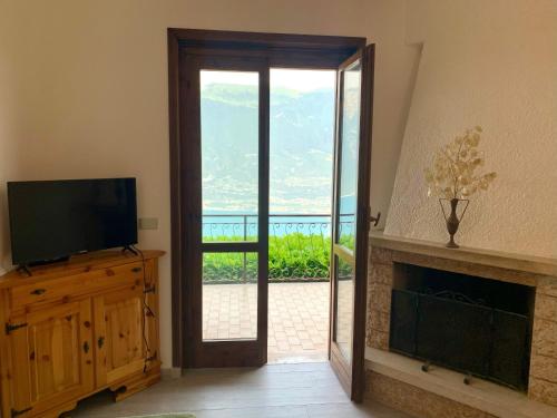 a living room with a television and a fireplace at Casa Eulberg Marcania Balcone vista lago in Tremosine Sul Garda