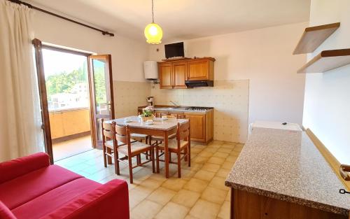 una pequeña cocina con mesa y sofá rojo en Casa Bellicini appartamento Balcony Lake View Park, en Tremosine Sul Garda