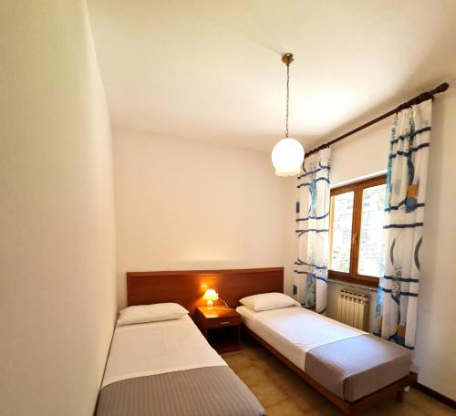 um quarto com duas camas e uma janela em Casa Bellicini appartamento Balcony Lake View Park em Tremosine Sul Garda