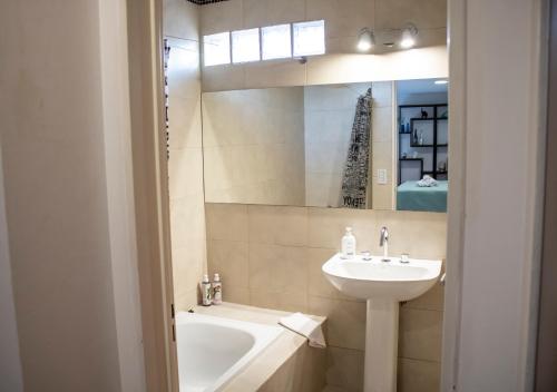 a bathroom with a sink and a bath tub and a mirror at Ayres de Saavedra - Dot Baires Shopping in Buenos Aires