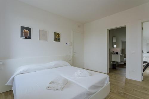 a white bedroom with a bed with white sheets at Yourbanflat White River 2 in Padova