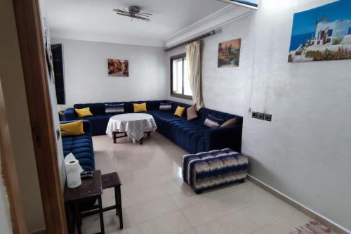 sala de estar con sofá azul y mesa en Appartement à Blanca Beach., en Casablanca