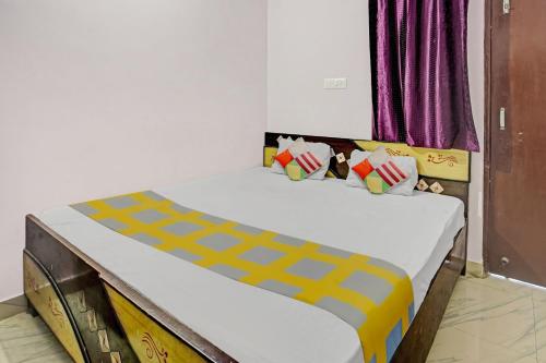 - une chambre avec un lit jaune et orange dans l'établissement Super OYO Hotel Happy Inn, à Patna