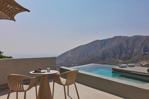 a table and chairs on a balcony with a view at Aeon Suites - Adults Only in Pirgos