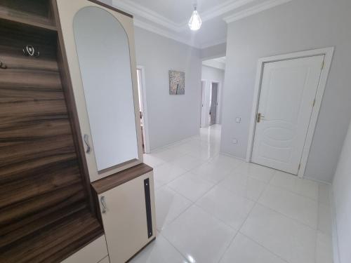 un corridoio bianco con specchio e porta di Garden City Sumqait 3 oda 100m2 daire a Sumqayıt