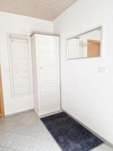 a room with two white closets and a mirror at Ferienwohnung -Time to relax- bei Bamberg, mit herrlichem Blick auf das Maintal in Viereth-Trunstadt