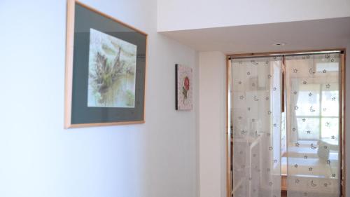 a bathroom with a shower and a picture on the wall at 田舎の静かな古民家の悠水居 in Itoman