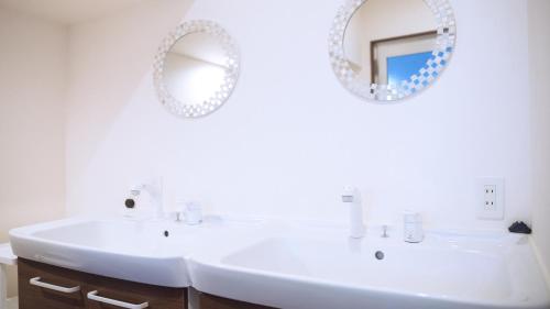a bathroom with a white sink and a mirror at 田舎の静かな古民家の悠水居 in Itoman