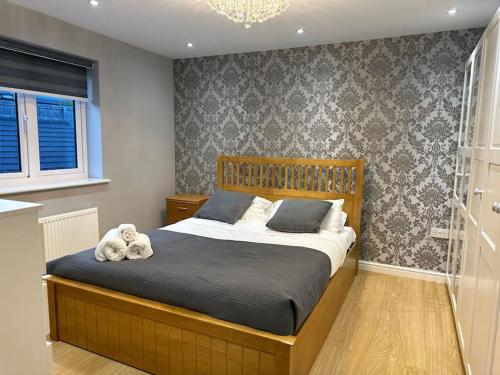 een slaapkamer met een bed met een teddybeer erop bij Stunning 4-Bedroom Home in Basingstoke