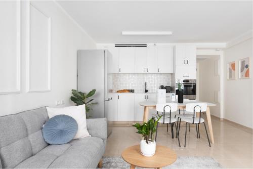 a living room with a couch and a table and a kitchen at Mate ALMA - By HOMY in Jerusalem