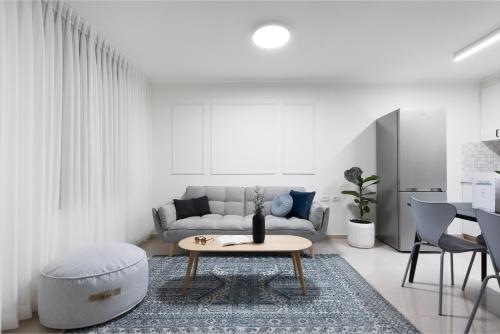 a living room with a couch and a table at Mate ALMA - By HOMY in Jerusalem
