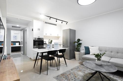 a living room with a couch and a table and chairs at Mate ALMA - By HOMY in Jerusalem