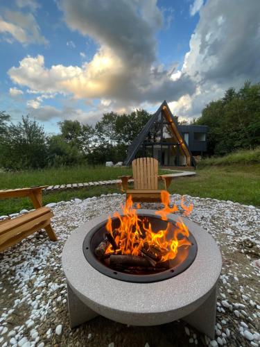 eine Feuerstelle mit einem Stuhl darüber in der Unterkunft Cabana A-frame Cricov 9 in Valea Lungă-Ogrea
