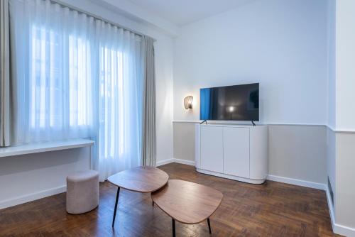 a room with two stools and a flat screen tv at Casa Navarino by Immobilis in Nafplio