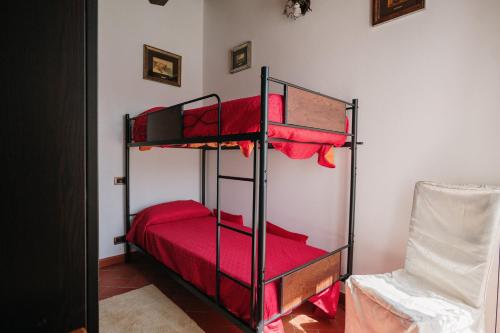 a bedroom with two bunk beds with red sheets at Lago del Turano - Guest House il Nido dell'Aquila in Ascrea